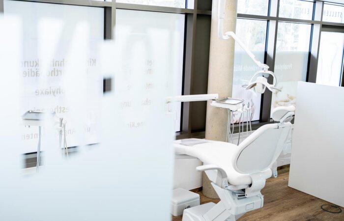 Zahnarztstuhl im Behandlungsraum Kieferorthopädie vor Glastür mit Milchglasfolie Zahnarztstuhl im Behandlungsraum Kieferorthopädie vor Glastür mit Milchglasfolie